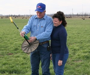 Farmers with pasture measuring tool